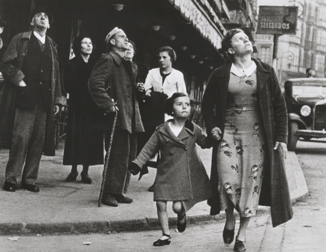 Woman and girl running for shelter on Gran Via during an air-raid, Bilbao, Spain, May 1937 Robert Capa / International Center of Photography / Magnum Photos / Capa Center – Budapest Photos: Hungarian Collection of The Robert Capa Photographs – Robert Capa Contemporary Photography Center, Budapest 
