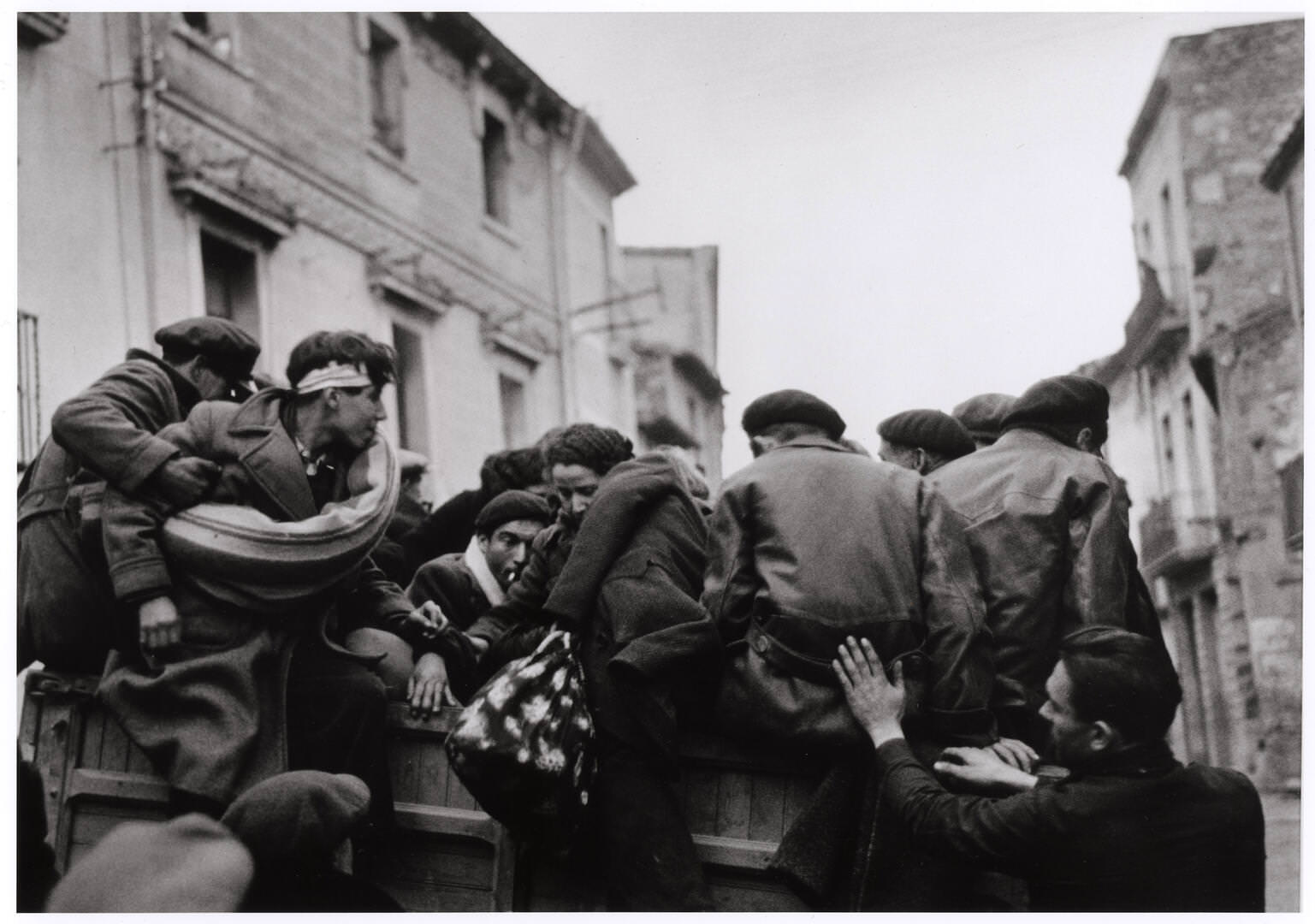 Refugees on a truck fleeing Barcelona and seeking asylum in France, along the road to the French border, Spain, January 25-27, 1939 Robert Capa / International Center of Photography / Magnum Photos / Capa Center – Budapest Photos: Hungarian Collection of The Robert Capa Photographs – Robert Capa Contemporary Photography Center, Budapest 