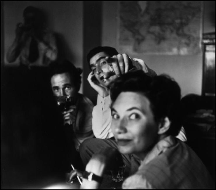 Magnum Photos-ügynökség találkozó. Werner Bischof és Robert Capa, előtérben Maria Eisner, az ügynökség első titkára. Párizs, Franciaország, 1950│ Magnum Photos meeting. Photographers Werner Bischof and Robert Capa, and in foreground Maria Eeisner the Bureau Chief. Paris, France, 1950. © Werner Bischof Estate/Magnum Photos 